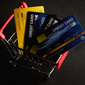 Assorted credit cards placed in a small shopping cart, symbolizing the search for the best cashback credit card.