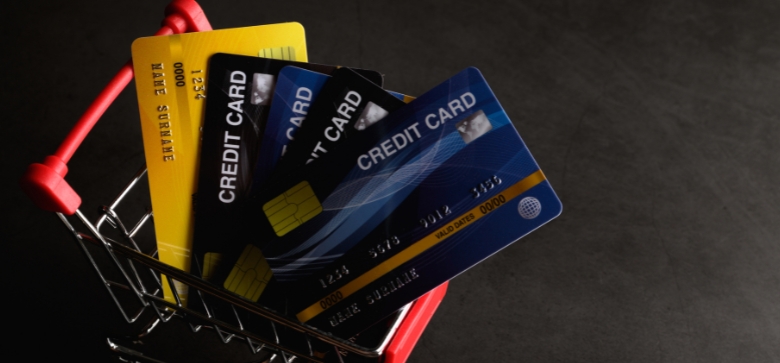 Assorted credit cards placed in a small shopping cart, symbolizing the search for the best cashback credit card.